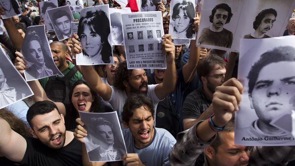 Ativistas seguram fotos de desaparecidos durante regime militar brasileiro em frente a um clube militar no Centro do Rio de Janeiro, 29 de março de 2012 - Sputnik Brasil