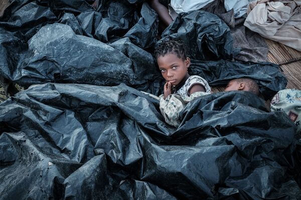Duas irmãs, de 11 e 6 anos, se escondem em abrigo improvisado de plástico após o ciclone devastador que afetou Moçambique - Sputnik Brasil