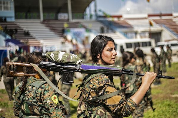 Jovens de um destacamento das Unidades de Proteção das Mulheres (YPJ) tomam parte no desfile militar dedicado à destruição total do Daesh (organização terrorista proibida em vários países, incluindo a Rússia), no leste da Síria - Sputnik Brasil