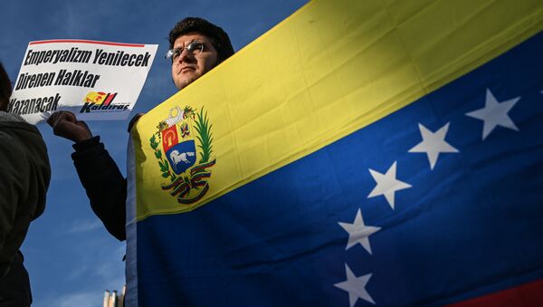 Um ativista de esquerda turco segura uma bandeira nacional venezuelana e um cartaz que se traduz como O imperialismo perderá, o povo resistente vencerá - Sputnik Brasil