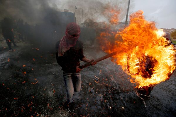 Palestino segura pneu em chamas durantes confrontos com forças israelenses - Sputnik Brasil