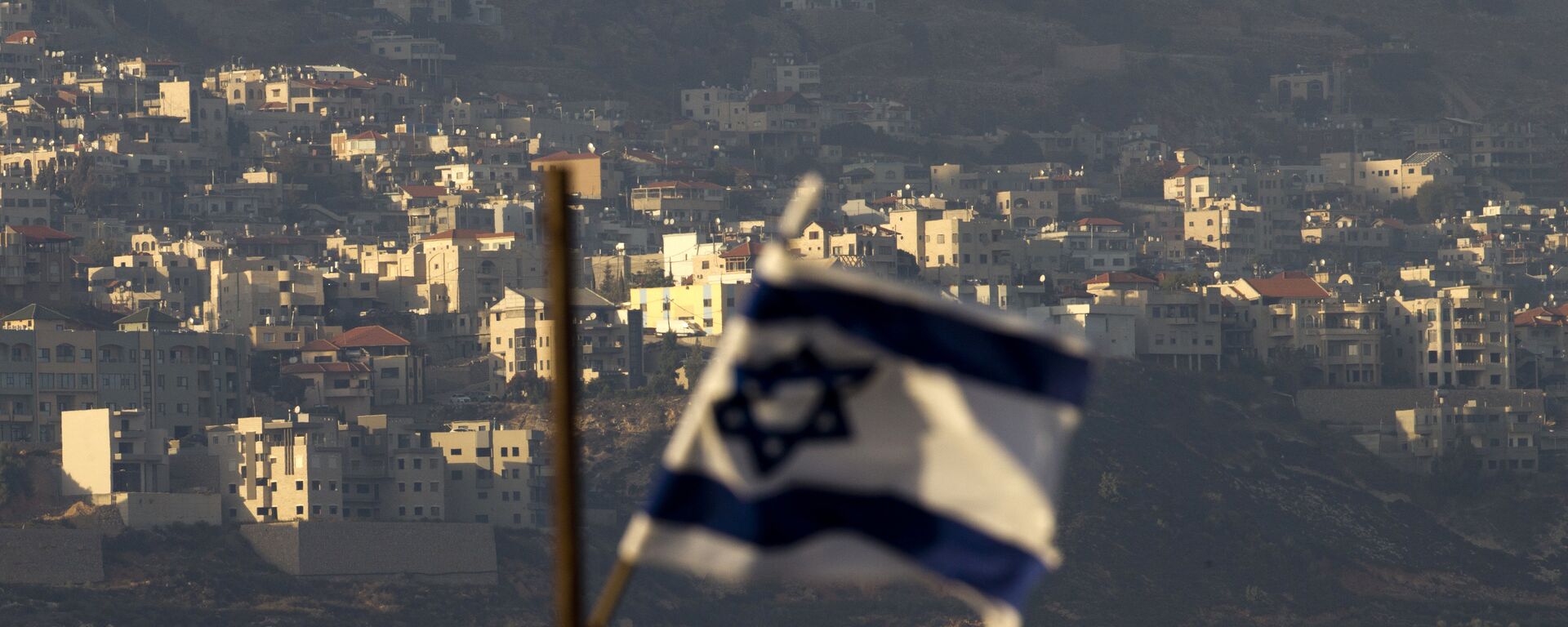 Bandeira israelense em frente à aldeia de Majdal Shams nas colinas de Golã controladas por Israel - Sputnik Brasil, 1920, 14.04.2024