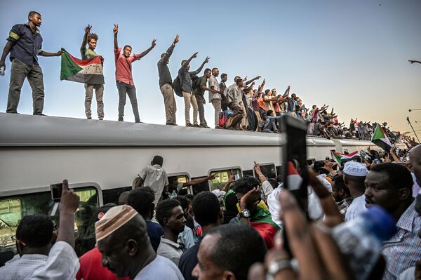 Manifestantes sudaneses no teto de um trem no decurso dos confrontos entre a oposição e o Conselho Nacional de Transição - Sputnik Brasil