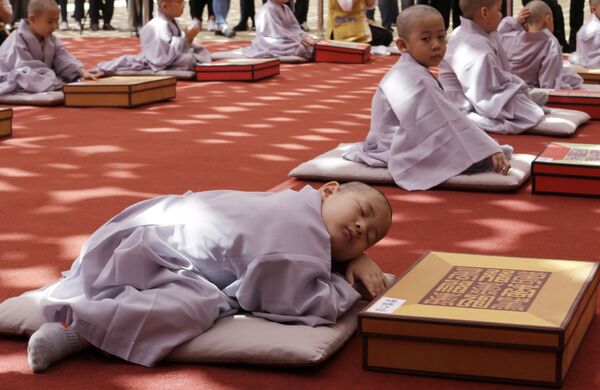 Menino dormindo após a cerimônia de raspagem de cabelo e ordenação como monge realizada em homenagem ao 2563º aniversário do Buda em um tempo em Seul, Coreia do Sul - Sputnik Brasil