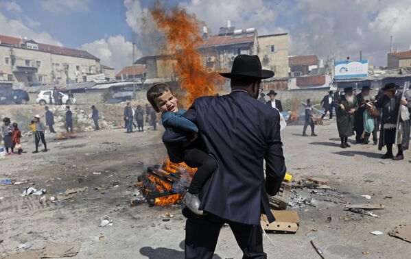 Judeu ultraortodoxo levando criança durante o ritual na véspera do Pessach (Páscoa judaica), em Jerusalém - Sputnik Brasil