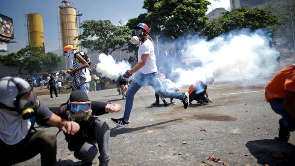 Opositores a Maduro se esquivam de gás lacrimogêneo perto da base aérea La Carlota, em Caracas - Sputnik Brasil