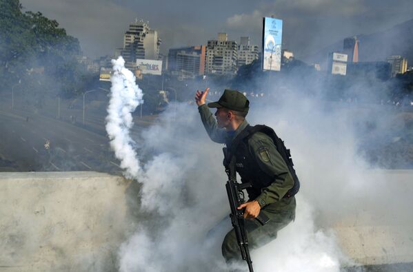 Um dos soldados apoiadores de Juan Guaidó coberto por fumaça perto da base aérea La Carlota, em Caracas - Sputnik Brasil