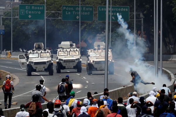 Veículos blindados das Forças Armadas da Venezuela se aproximam dos manifestantes perto da base aérea La Carlota, em Caracas - Sputnik Brasil