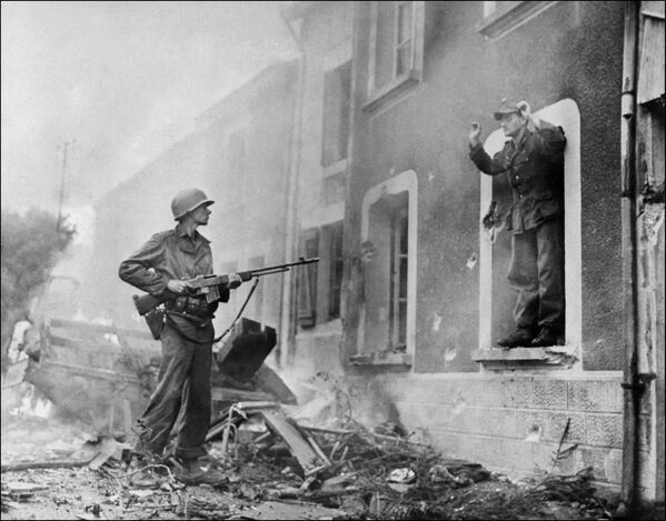 Soldado americano aponta espingarda para um soldado alemão durante a luta pela libertação da França, 1944 - Sputnik Brasil