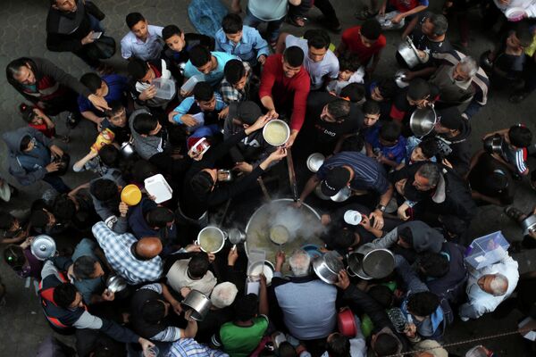 Palestinos se reúnem para receber sopa de graça durante o mês de jejum muçulmano do Ramadã, na Cidade de Gaza, 9 de maio de 2019. - Sputnik Brasil