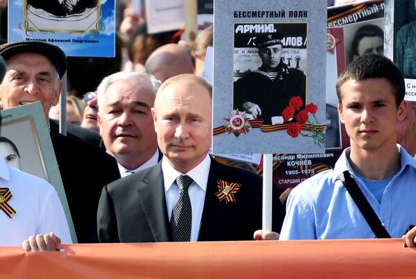 O presidente russo, Vladimir Putin, com um retrato do seu pai, veterano de guerra, durante a marcha do Regimento Imortal dedicada ao Dia da Vitóriaй полк - Sputnik Brasil