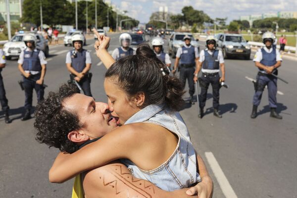 Um casal se beijando na frente da polícia durante protestos no Brasil - Sputnik Brasil