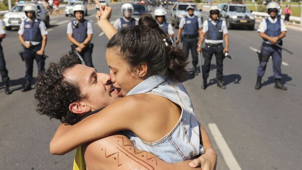 Um casal se beijando na frente da polícia durante protestos no Brasil - Sputnik Brasil