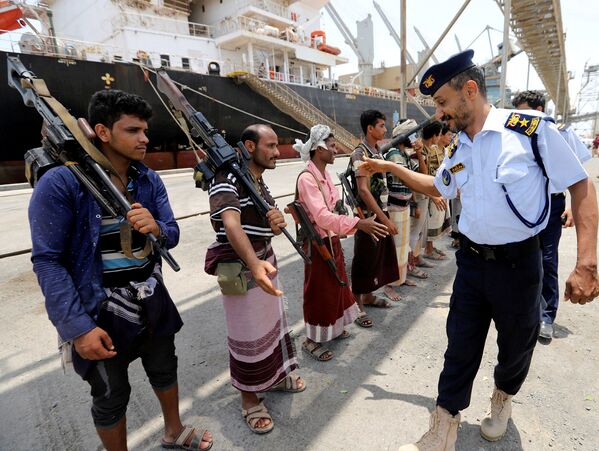 Oficial da Guarda Costeira iemenita cumprimenta hussitas quando estes deixam o porto de Saleef, na província de Hodeyda - Sputnik Brasil