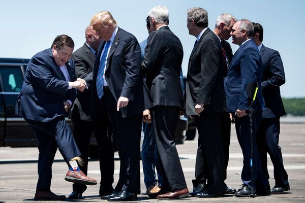 Vice-governador do estado americano de Louisiana Billy Nungesser mostra ao presidente dos EUA Donald Trump meias com sua imagem no aeroporto de Lake Charles - Sputnik Brasil