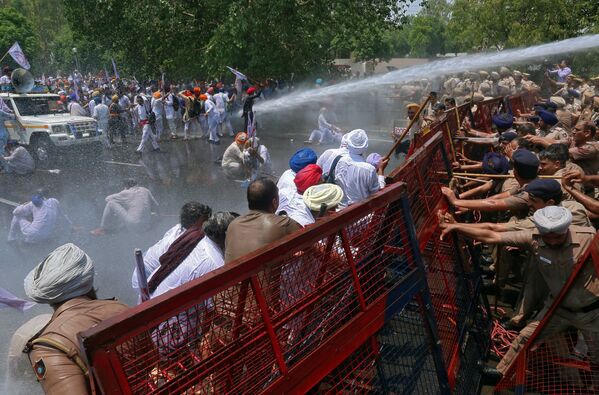 Manifestantes atingidos por jatos de água da polícia durante um protesto em Chandigarh, na Índia - Sputnik Brasil
