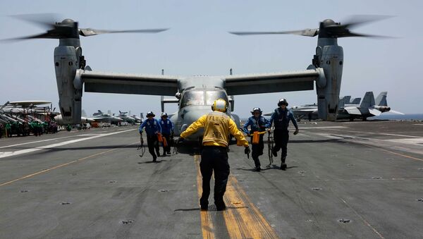 Militares retiram calços e cabos da aeronave multifunção MV-22 Osprey do Esquadrão Marine Medium Tiltrotor 264, no convés do porta-aviões USS Abraham Lincoln de classe Nimitz, durante as manobras em 17 de maio de 2019 - Sputnik Brasil