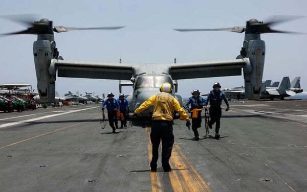 Militares retiram calços e cabos da aeronave multifunção MV-22 Osprey do Esquadrão Marine Medium Tiltrotor 264, no convés do porta-aviões USS Abraham Lincoln de classe Nimitz, durante as manobras em 17 de maio de 2019 - Sputnik Brasil