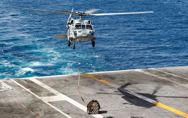 Helicóptero Sea Hawk transportando carga do navio de apoio USNS Arctic (T-AOE 8) para o porta-aviões norte-americano USS Abraham Lincoln durante um reabastecimento no mar Arábico, em 19 de maio de 2019 - Sputnik Brasil