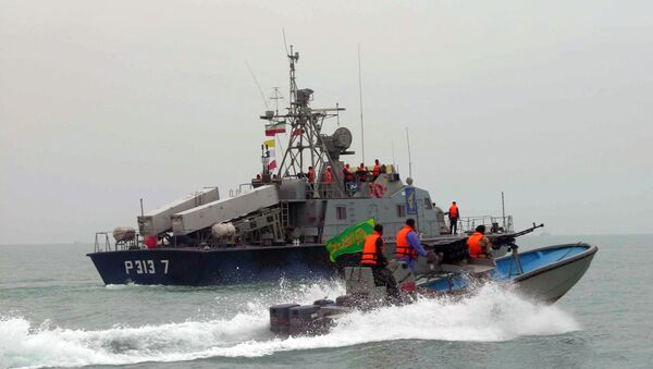 Membros da Guarda Revolucionária do Irã navegam próximo a uma embarcação iraniana durante manobras ao longo do mar do Golfo e do mar de Omã - Sputnik Brasil