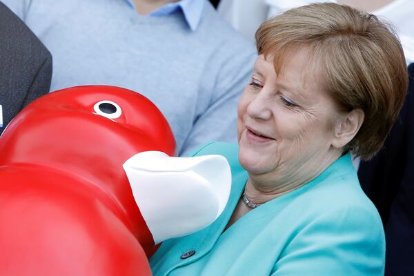 Chanceler alemã Angela Merkel recebe um presente ao visitar a empresa de biotecnologia Centogene em Rostock, Alemanha, 23 de maio de 2019 - Sputnik Brasil
