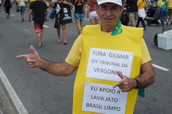 Apoiador do presidente Jair Bolsonaro é fotografado usando placa com frases críticas ao ministro do STF, Gilmar Mendes. - Sputnik Brasil