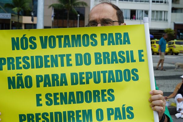 Apoiador do presidente Jair Bolsonaro carrega cartaz com críticas ao Congresso. - Sputnik Brasil