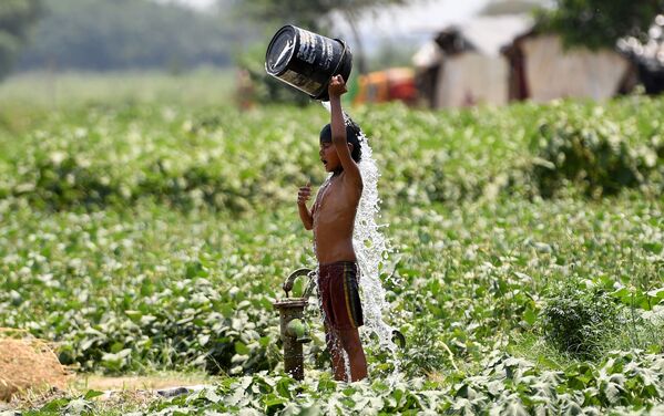 Menino se refresca com água nos dias quentes em Nova Deli, Índia - Sputnik Brasil