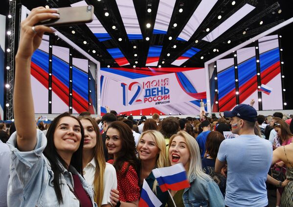 Jovens tiram foto durante show na Praça Vermelha, em Moscou, por ocasião do Dia da Rússia - Sputnik Brasil