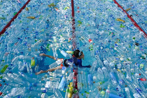 Criança nada em piscina cheia de garrafas de plástico durante uma campanha de sensibilização para assinalar o Dia Mundial dos Oceanos em Bangkok, 8 de junho de 2019 - Sputnik Brasil