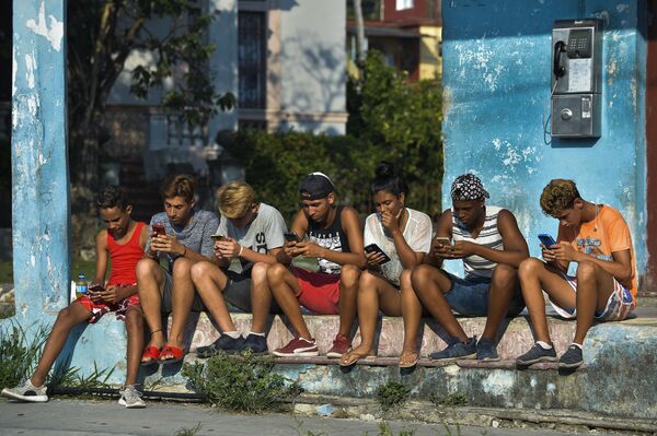 Jovens cubanos com telefones celulares em rua de Havana - Sputnik Brasil