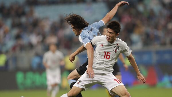 O jogador do Uruguai, Edinson Cavani, divide a bola com o jogador do Japão Takehiro Tomiyasu durante jogo do Grupo C da Copa América, em Porto Alegre. - Sputnik Brasil