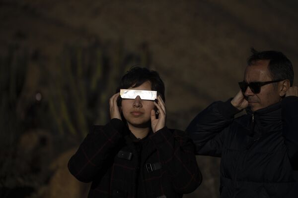 Pessoas com óculos especiais olhando o eclipse solar total em La Higuera, Chile, 2 de julho de 2019 - Sputnik Brasil