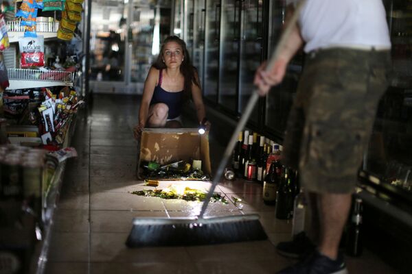 Kaitlin Alexander remove garrafas quebradas de um supermercado após o terremoto - Sputnik Brasil