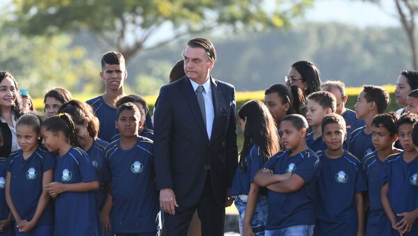 Presidente do Brasil, Jair Bolsonaro, rodeado por crianças durante cerimônia de hasteamento da Bandeira Nacional no Palácio da Alvorada, Brasília, 21 de maio de 2019 - Sputnik Brasil