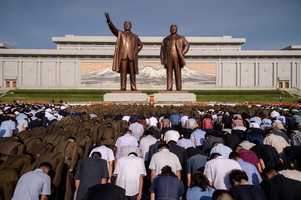 Moradores da cidade de Pyongyang (Coreia do Norte) durante um minuto de silêncio perto do monumento aos líderes norte-coreanos Kim Il-sung e Kim Jong-il, no 25º aniversário da morte de Kim Il-sung - Sputnik Brasil