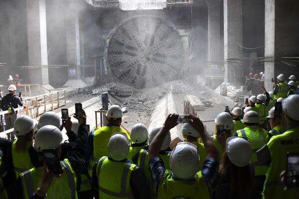 Operários tirando fotos a uma máquina de tunelamento durante a construção de uma nova estação do metrô em Moscou - Sputnik Brasil