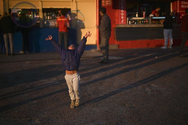 Menina apanhando bolhas de sabão em um parque de diversões em Montevideo, Uruguai - Sputnik Brasil