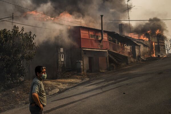 Morador usando máscara em frente a casa em chamas na aldeia de Roda, no centro de Portugal, em 21 de julho de 2019 - Sputnik Brasil