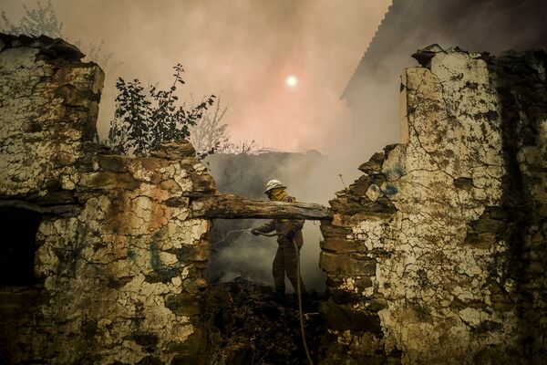 Bombeiro da Guarda Nacional usa mangueira durante incêndio na aldeia de Roda, no centro de Portugal, em 21 de julho de 2019 - Sputnik Brasil