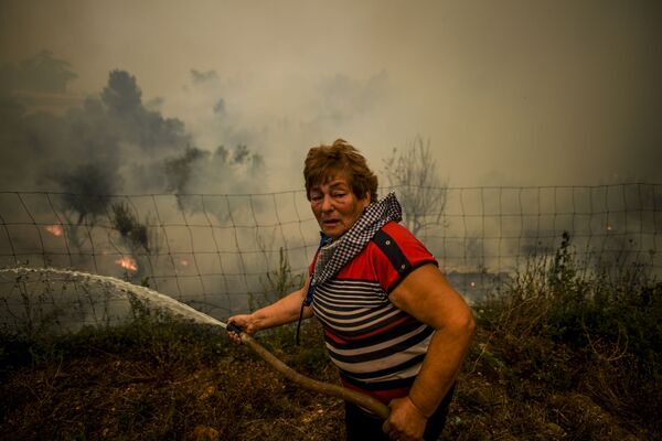Aldeão usa mangueira de água para apagar chamas durante incêndio na aldeia de Roda, no centro de Portugal, em 21 de julho de 2019 - Sputnik Brasil