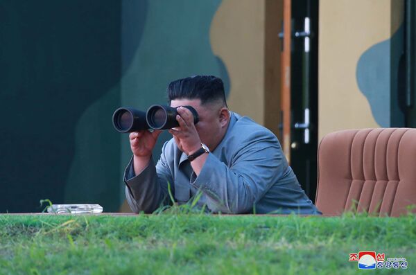 Líder norte-coreano Kim Jong-un observa através de binóculos o lançamento de mísseis balísticos - Sputnik Brasil