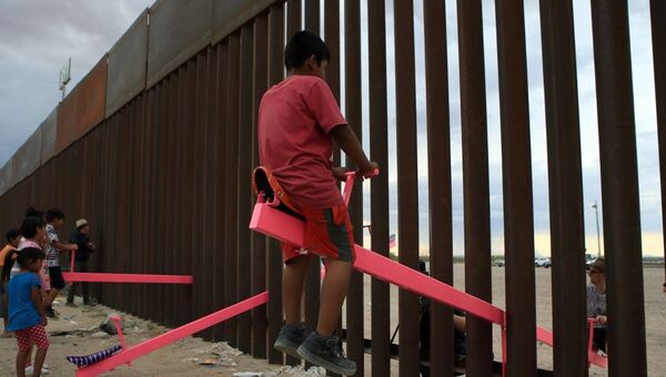 Arquiteto instala gangorras em muro na fronteira entre México e EUA e crianças brincam separadas pela barreira. Foto em 28 de julho de 2019. - Sputnik Brasil