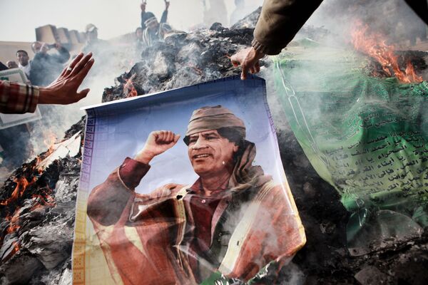 Moradores de Benghazi queimam retrato de Kadhafi, cartazes com citações dele e seu Livro Verde - Sputnik Brasil