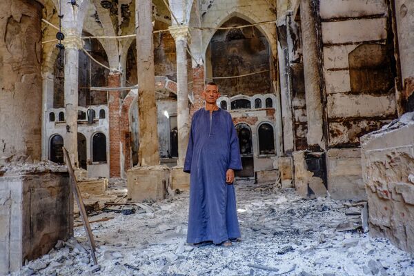 Um copta em uma das igrejas coptas destruídas na província egípcia de Minia - Sputnik Brasil