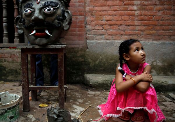 Garota sentada ao lado de cabeça de demônio no Nepal
 - Sputnik Brasil
