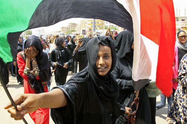 Uma jovem sudanesa com a bandeira nacional durante a celebração da assinatura do Acordo Constitucional entre o Conselho de Guerra e a Frente Nacional de Libertação do país sobre o estabelecimento de um governo de transição
 - Sputnik Brasil