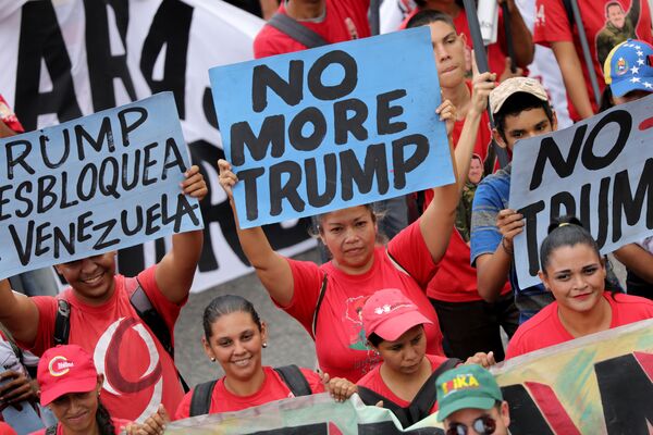 Apoiadores do governo da Venezuela empunhando cartazes contra o presidente dos EUA, Donald Trump, durante o protesto contra as sanções norte-americanas - Sputnik Brasil