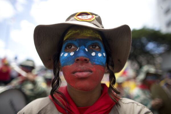 Moça com a cara pintada de cores da bandeira nacional durante a manifestação contra as sanções aplicadas pelos EUA, em Caracas - Sputnik Brasil