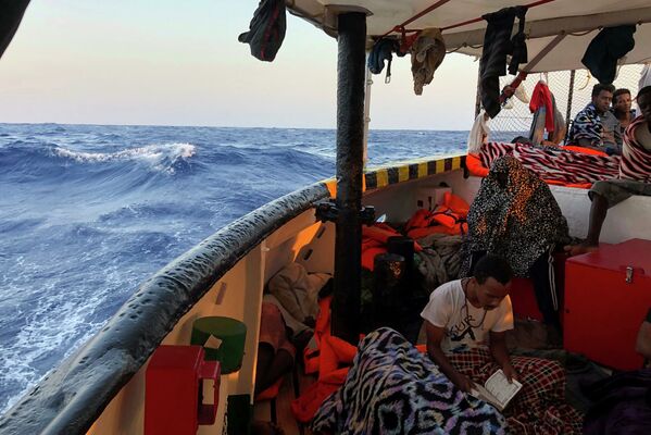 Imigrante lê o Corão a bordo do navio dos socorristas espanhóis Open Arms no mar Mediterrâneo - Sputnik Brasil